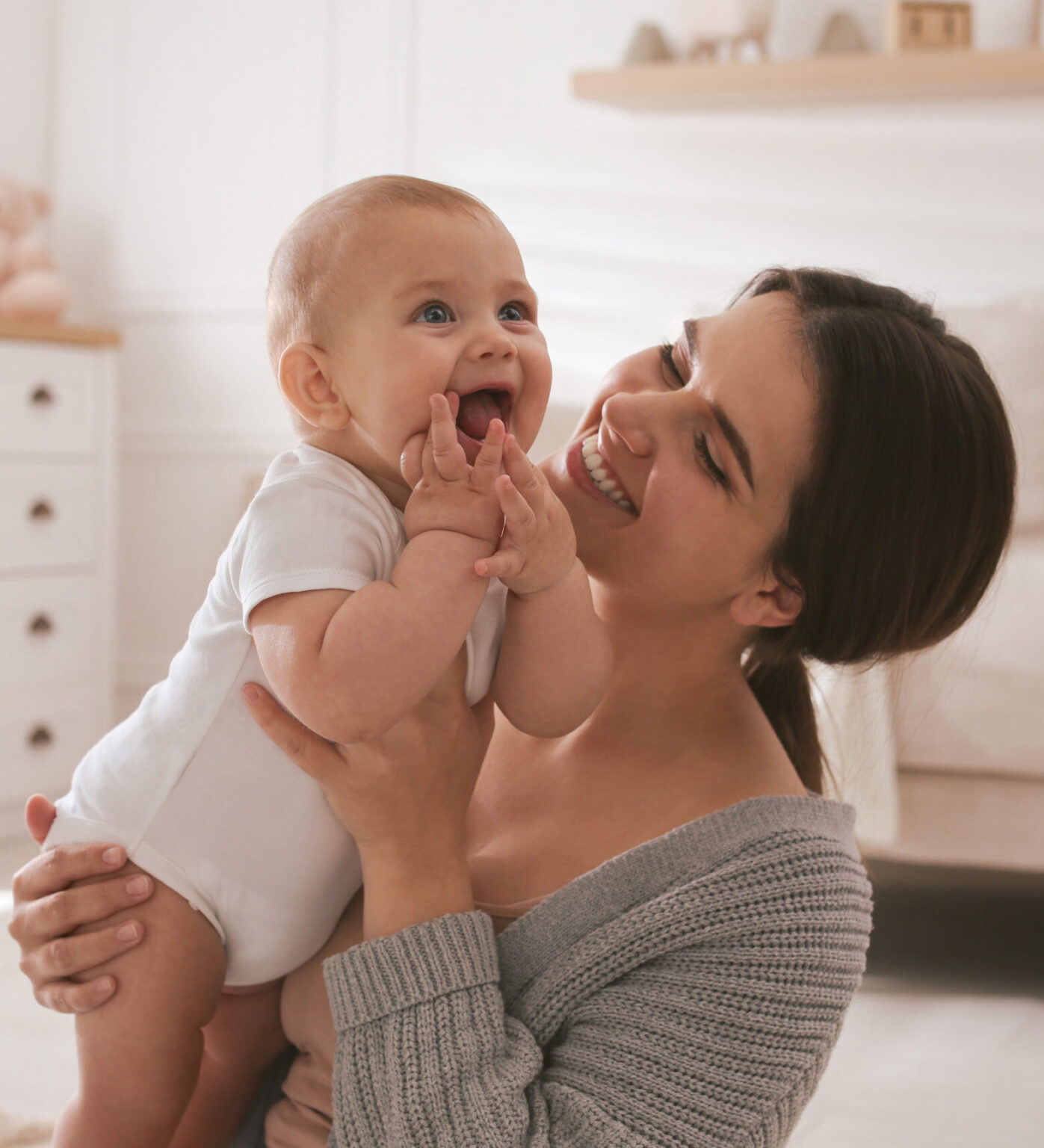 happy baby with mother in nursery